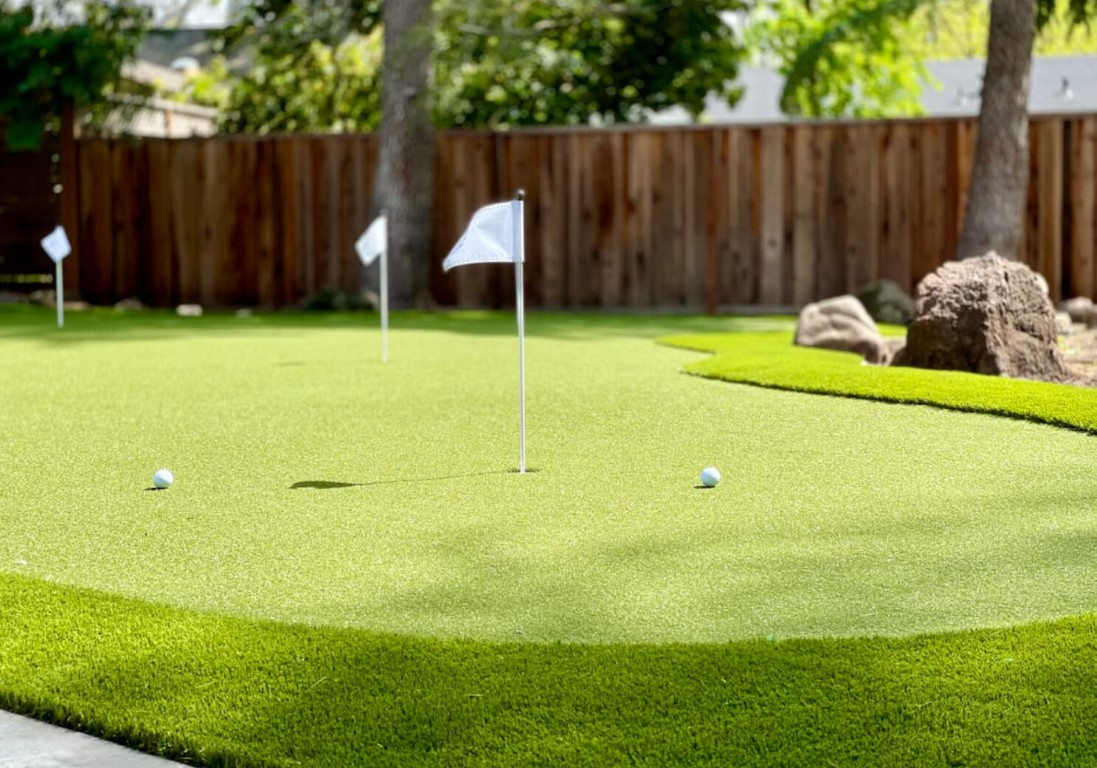 Custom backyard putting green installation with flags in Lehigh Acres, FL